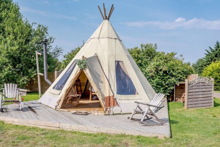 A glamping Baby Tipi on a raised wooden decking in the countryside