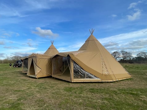 A group of tents in a field

AI-generated content may be incorrect., Picture